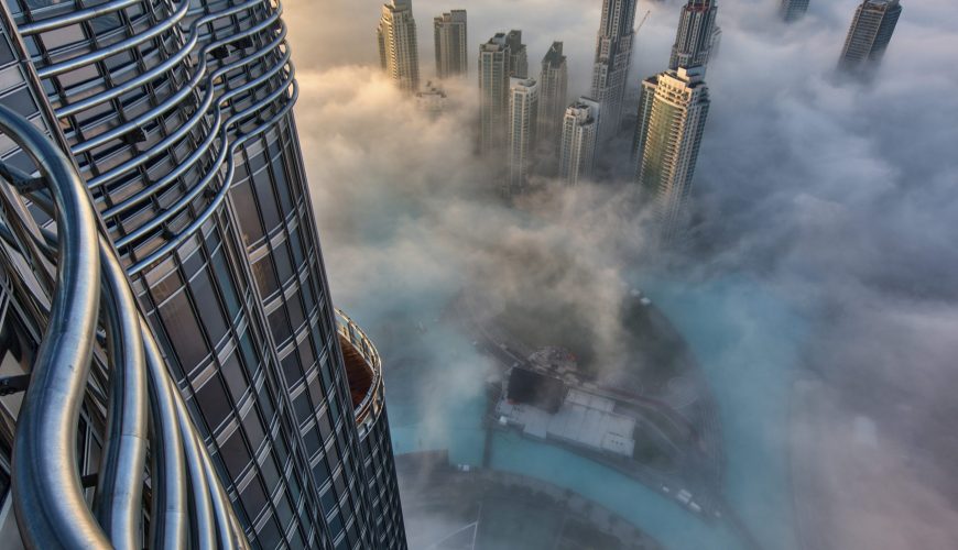 Aerial view of cityscape with skyscrapers above the clouds in Dubai, United Arab Emirates.